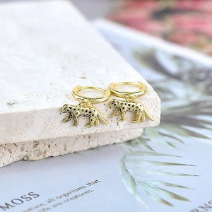 Vintage gold leopard drop earrings with s925 silver needles on a textured stone display