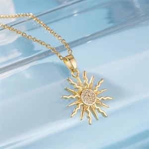 Golden sunflower necklace with sparkling zircon micro-inlays on light blue glass background