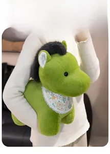 Detail view of a soft green plush pony toy with floral lace bib held in hand