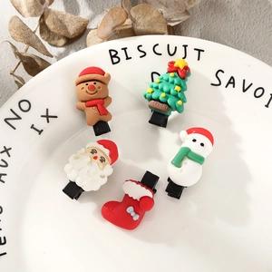 Close-up of 5pcs Christmas hair clips with Santa and snowman on a ceramic plate