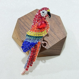 Vintage parrot brooch with colorful rhinestones and a large red crystal in rose gold