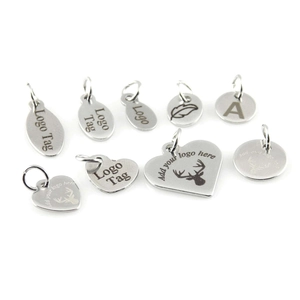 Detailed view of silver stainless steel custom charms in heart, oval and round shapes