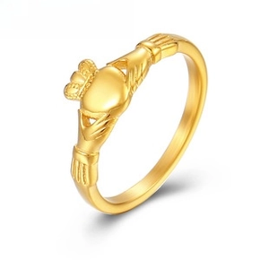 Macro shot of rose gold Claddagh ring featuring hands holding a crowned heart symbol