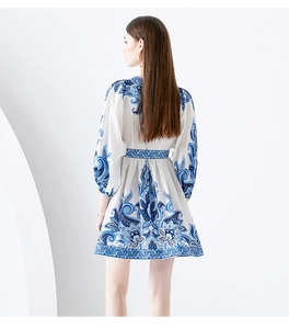 Detail of bohemian blue floral print on white mini dress with matching waist belt and puff sleeves