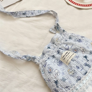 Détail du sac de téléphone en seersucker bleu clair avec motifs de dessin et dentelle
