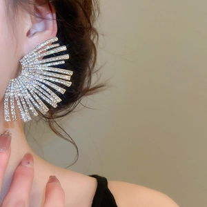 Detailed close-up of fan-shaped rhinestone earrings worn by a model for elegant parties