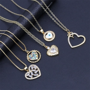 Detailed view of gold plated necklaces with heart and evil eye zircon pendants