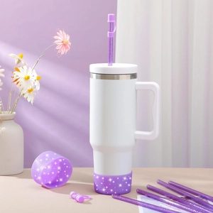 White vacuum tumbler with purple glitter silicone boot and matching straw accessories