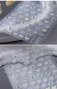 Macro detail of TL-217 heart nail stickers with aurora finish and rhinestone accents