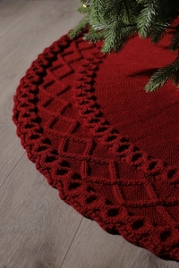 Gros plan de la jupe de sapin de Noël rouge tricotée avec de grands motifs de losanges