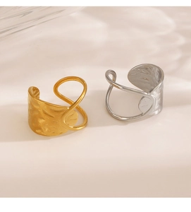 Macro detail of geometric hammered metal rings in gold and silver on marble background