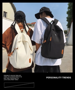 Outdoor shot showing black and white street style backpacks for students on models