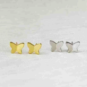 Detailed macro view of butterfly stud earrings in polished gold and silver metallic finishes