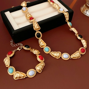 Detail of vintage gold jewelry set with colorful geometric triangular beaded accents