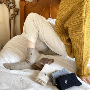 Detail of five colors of thick winter knit socks with delicate floral rose embroidery