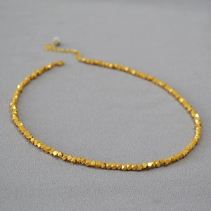 Detail shot of faceted gold beads necklace with adjustable extension chain and metal clasp