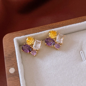 Detailed shot of multi-colored zircon oval earrings in a luxury wooden gift box