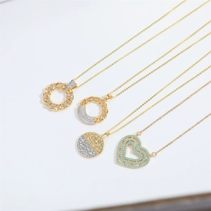 Close-up of four gold multilayer necklaces featuring zircon heart and ring pendants