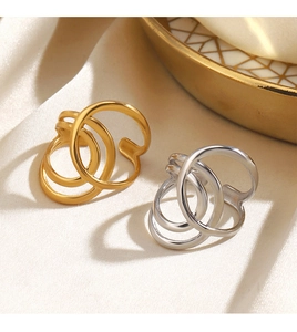 Close-up of gold and silver minimalist cross-line open rings on beige silk fabric