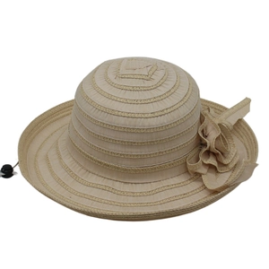Detail of beige wide brim sun hat with floral ornament and adjustable black toggle