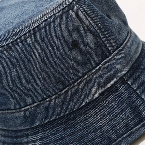Detail shot of the reinforced stitching and breathable eyelets on denim bucket hat