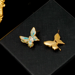 Enamel butterfly stud earrings with blue wings and teardrop zircon on a jewelry box