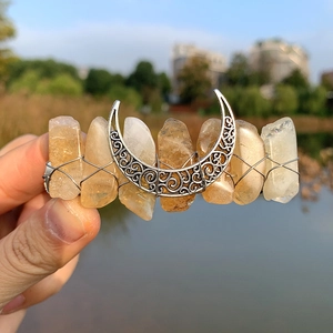 Detail of yellow raw crystal hair clip with silver crescent moon pendant and wire wrapping
