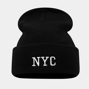 Détail de la broderie NYC sur bonnet en maille noire avec texture de tricot précise