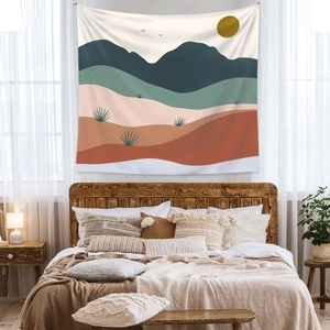 Detail of bohemian tapestry featuring geometric mountains and desert sun in warm earthy tones