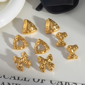 Set aus goldenen geometrischen Ohrsteckern mit Schmetterlings- und Dreiecksformen auf Weiß