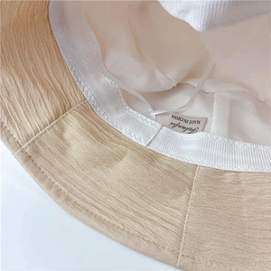 Détail de la doublure, de l'étiquette et de la texture plissée du chapeau bob beige