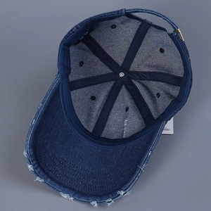 Detail view of denim baseball cap interior showing distressed edges and metal buckle