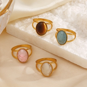 Minimalist stainless steel oval resin rings in four elegant colors on stone background