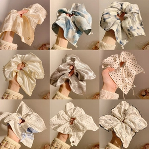 Collage of nine colorful patterned hair scrunchies in satin and floral fabric styles
