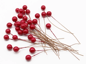 Close-up of artificial red berries with glossy finish and wire stems for DIY decor