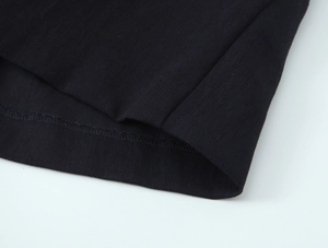 Detailed close-up showing the neat hemline stitching and texture of black knit fabric