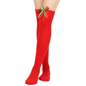 Detail of red over-knee Christmas socks featuring satin bows and ribbed knit texture