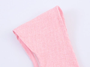 Detail showing the pink tweed woven fabric texture and stitching of the French style dress
