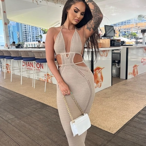 Dettaglio dell'abito beige in maglia crochet con eleganti tagli sulla vita e scollo