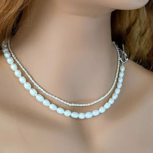 Detail of layered freshwater pearl necklace with silver heart OT toggle clasp on neck