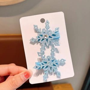 Detail of blue glitter snowflake hair clips with rhinestones on a white display card