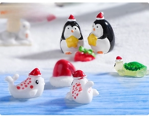 Miniature Christmas sea animals with Santa hats in a micro landscape winter snow scene