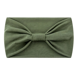 Detail of olive green stretchy yoga headband featuring a soft fabric knotted bow design
