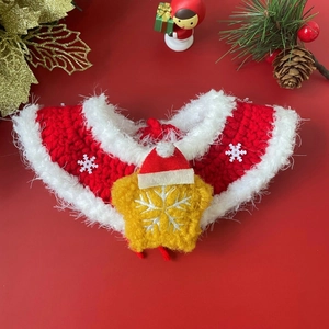 Detail of red and white knitted pet Christmas collar with star and tiny Santa hat