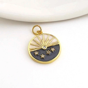 Detailed close-up of a round gold-plated pendant with black enamel stars and white crescent
