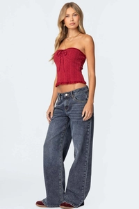 Side view of woman in red tube top and loose wide-leg dark blue vintage jeans