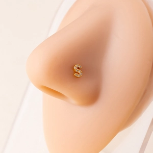 Gold letter S nose stud with cubic zirconia on a realistic nose model display