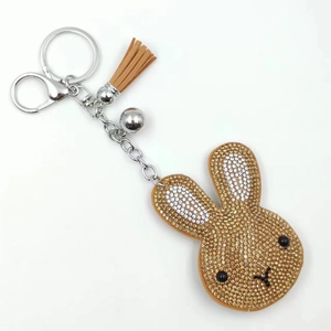 Sparkling rabbit head keychain with brown tassel and gold rhinestones on white background