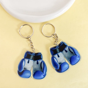 Detail of blue acrylic boxing glove keychains with metallic ring on a plain background