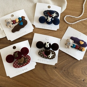 Close-up of flocking cartoon bear hair clips with polka dots and resin details